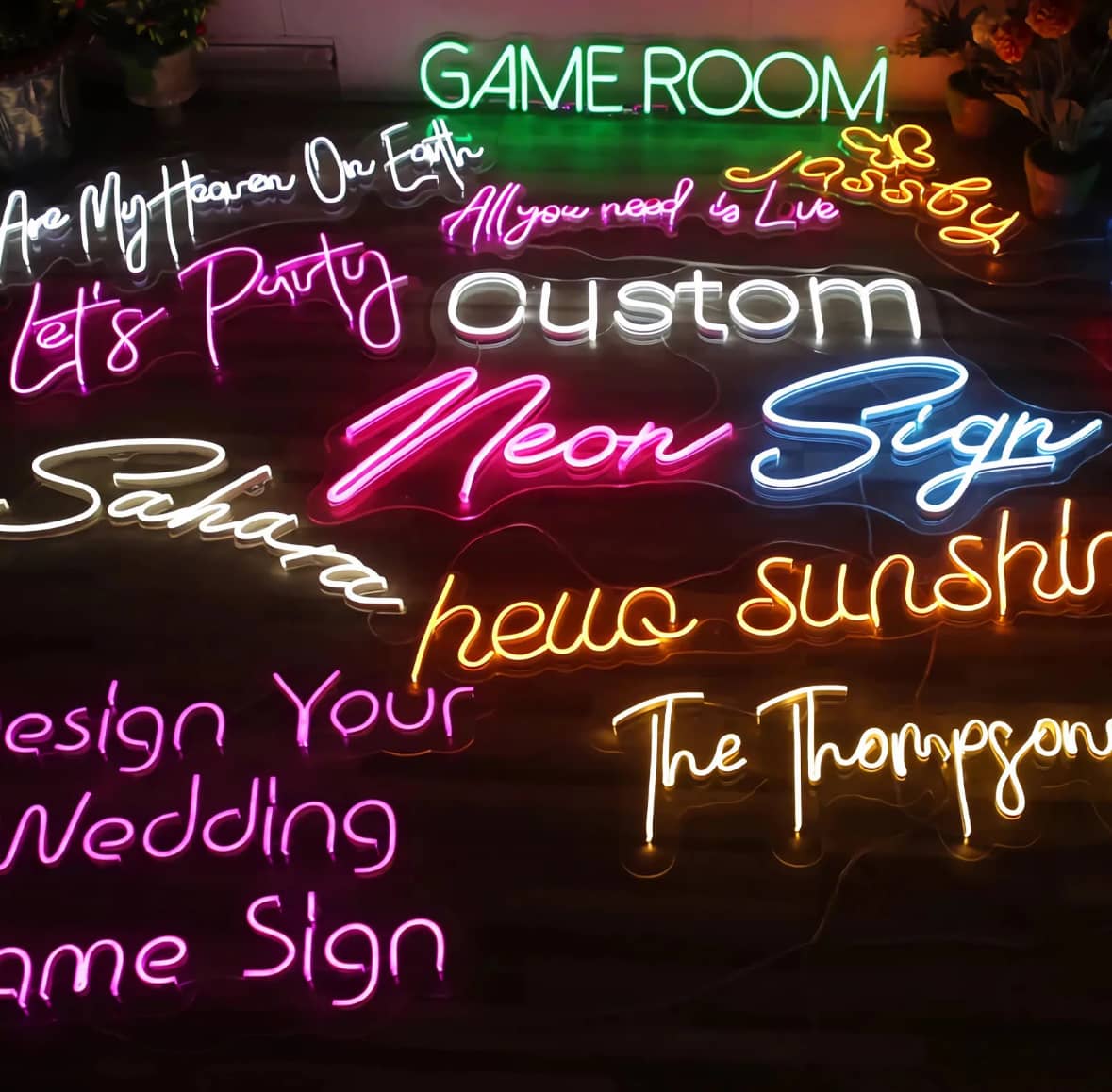 Verschiedene personalisierte Neon-LED-Schilder in bunten Farben mit individuellen Schriftzügen wie 'Game Room', 'Neon Sign' und 'Let's Party'. Perfekte Wanddekoration für Events, Hochzeiten und moderne Räume.